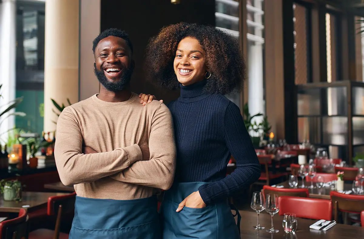 Couple laughing at the camera in a coffee shop