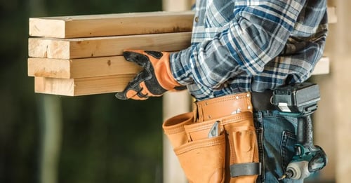 Carpenter carrying wooden boards