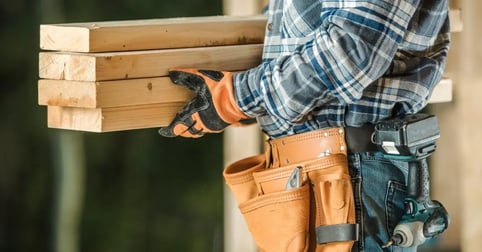 Carpenter carrying wooden boards