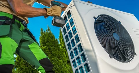 Contractor installing AC unit outdoors