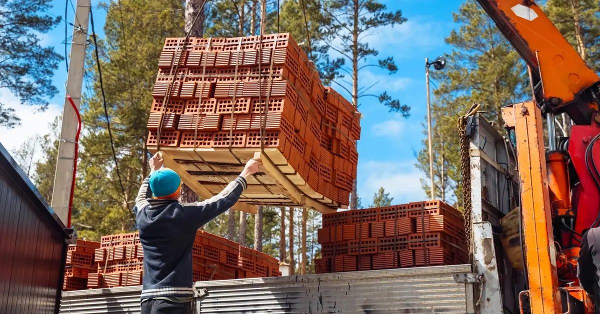 Worker unloading bricks from truck