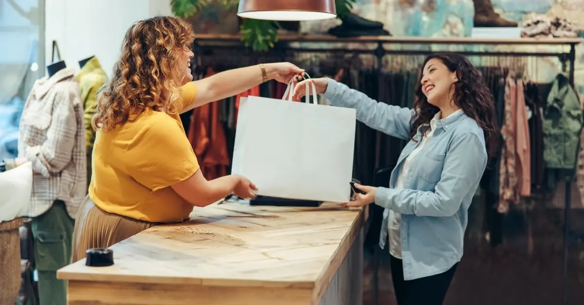 Store owner handing bag to customer