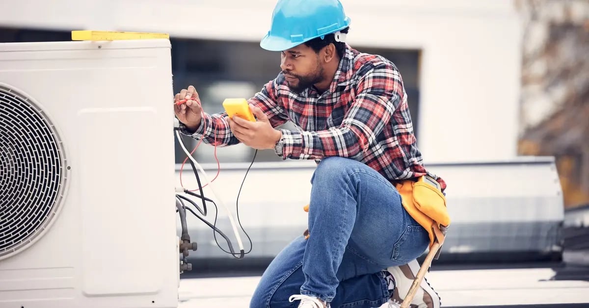 Technician working on rooftop HVAC unit