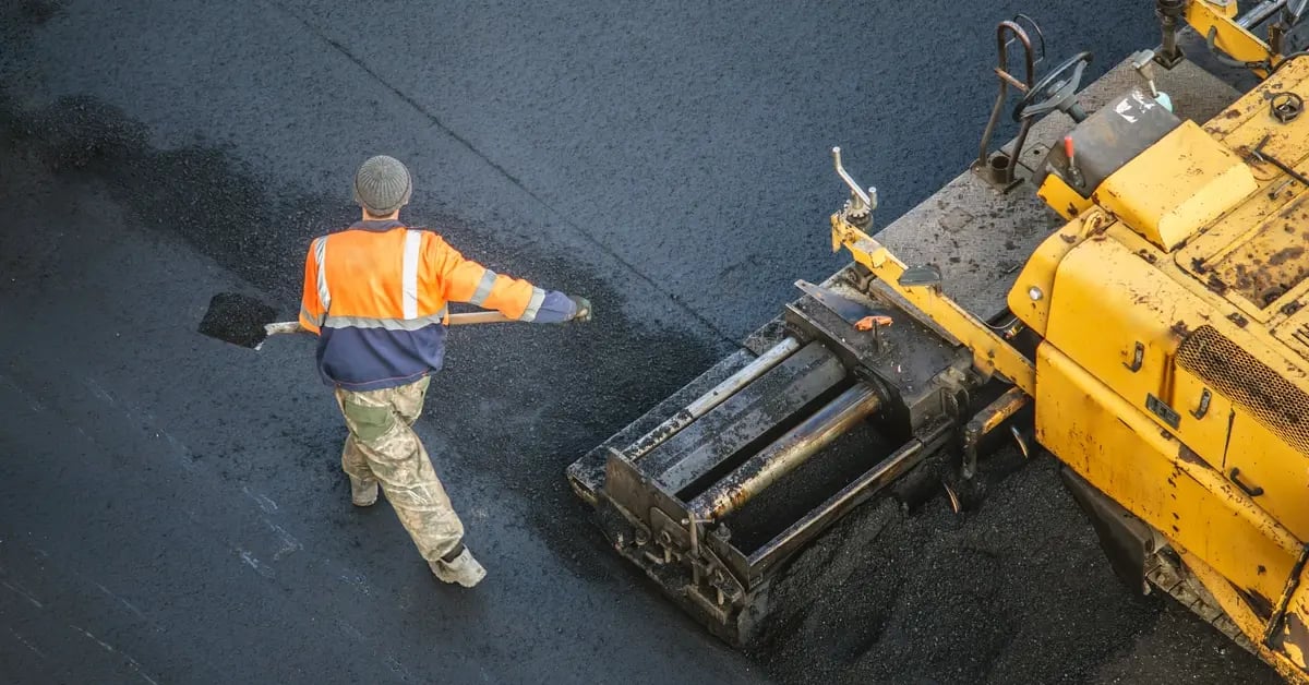 worker-laying-asphalt-around-heavy-machinery