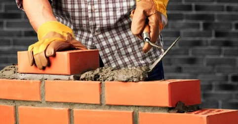 Masonry worker laying brick