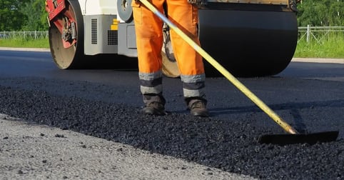 Worker leveling asphalt